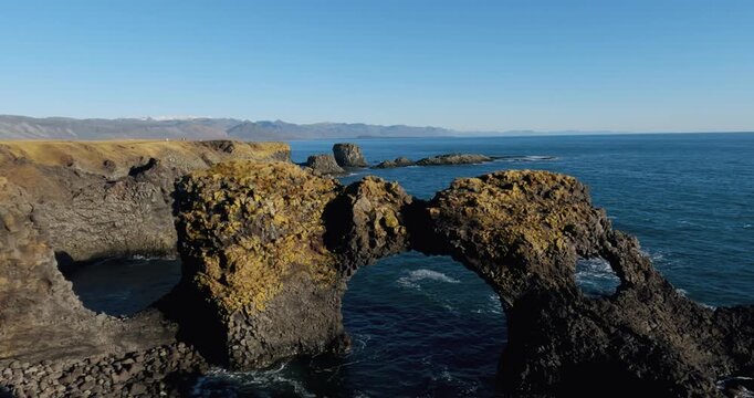 Amazing stone arch Gatklettur basalt rock on Atlantic coast of Arnarstapi in Iceland. The famous natural form arch attracts tourist to visit west of Iceland.