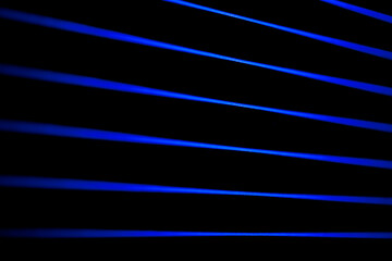 Fototapeta premium Thin blue lines slice a black field. Laser lines.