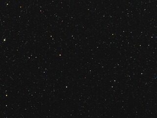Obraz premium Macro photography of deep black background with sparse colorful starry sparkles