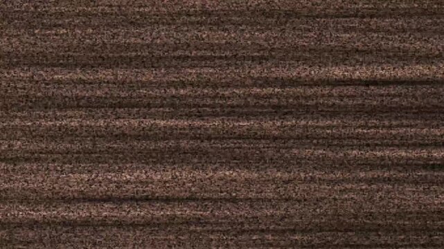Textured brown static noise background with horizontal lines, perfect for a gritty, retro, or distressed visual effect.A loopable video featuring a brown, textured background of static noise with