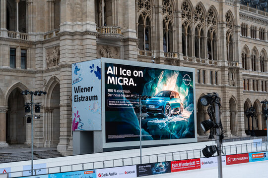 Vienna, Austria- Feb 21, 2026: A large advertisement for Nissan Micra showcases an electric car in a wintery setting at Wiener Eistraum event, attracting public interest.
