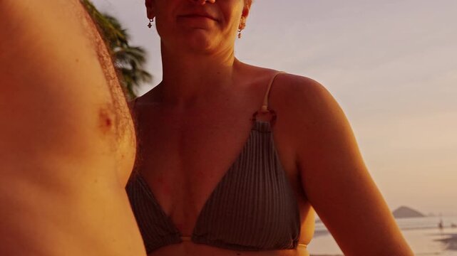 Close Up of Woman Gently Twisting Man Nipple During Intimate Moment at Beach Sunset, Warm Golden Light, Playful Teasing Mood, Adult Sensual Interaction