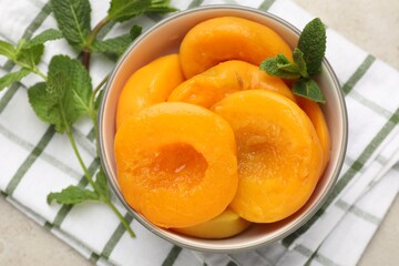 Pickled peaches and mint leaves in bowl on light grey table, flat lay © New Africa