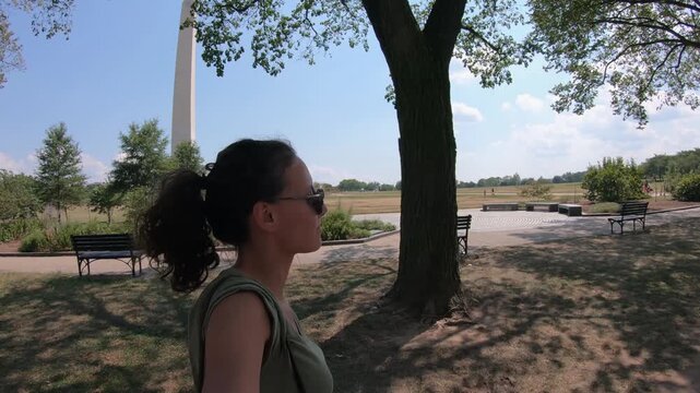 Woman POV walking in the park with view of the Washington Monument in the background in Washington, DC, USA on a hot summer day.