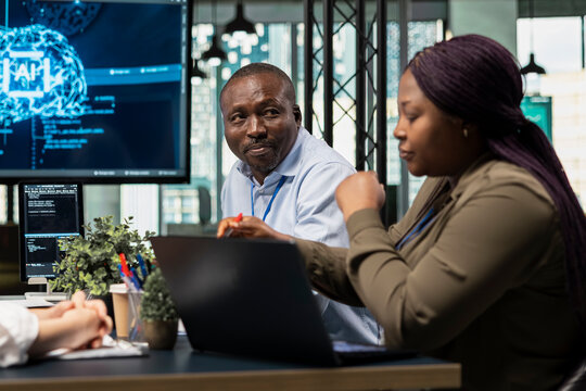 Technicians in AI neural network startup office brainstorming, building scalable solutions for businesses. IT staff members doing meeting to discuss deep learning tech implementation