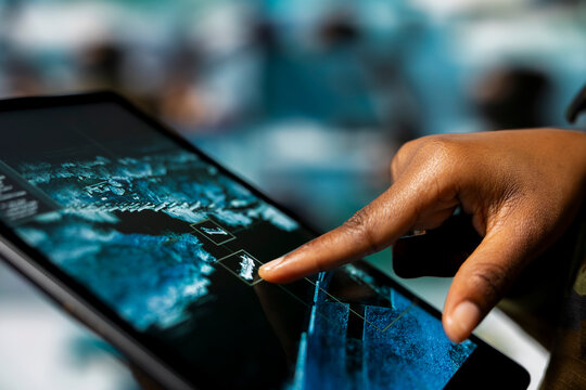 Close up of army soldier using device app to track hostile threats. Communications specialist in command center using target acquisition tech on tablet to detect enemy location