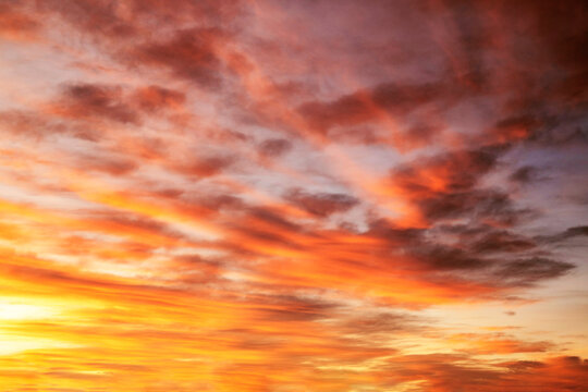 Dramatic and colorful winter sunrise sky, with clouds filled with colors of orange, yellow, pink and purple, just before the sun rises at the dawn of a new day.