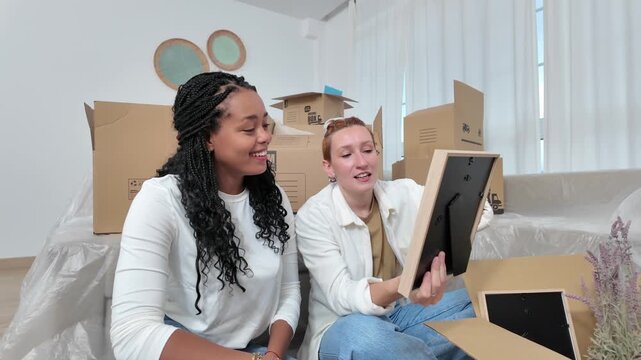 Lesbian couple unpacking boxes in new home