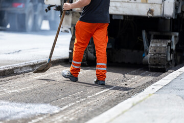 Road worker operating asphalt milling machine removing old pavement from street © zphoto83