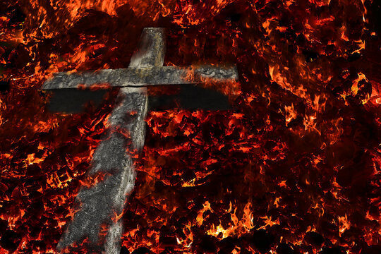 Ein steinernes Kreuz steht in Flammen. Ein Steinkreuz im Feuer
