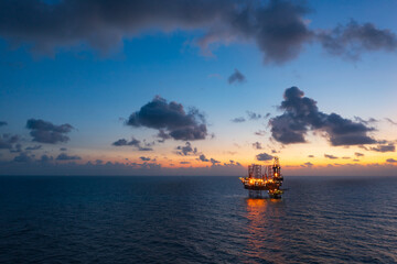 Obraz premium Aerial view of offshore jack up rig and offshore platform during sunset for oil and gas exploration and production.
