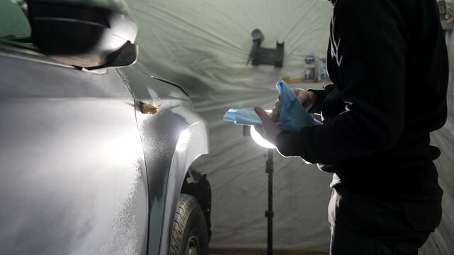 Professional detailer degreasing a car surface