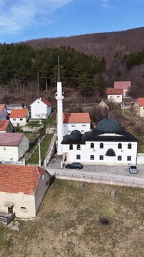 White mosque with green dome and minaret in Guber village near Livno