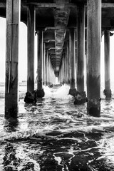 Fototapeta premium Black and white perspective under the Huntington Beach Pier in Huntington Beach, California
