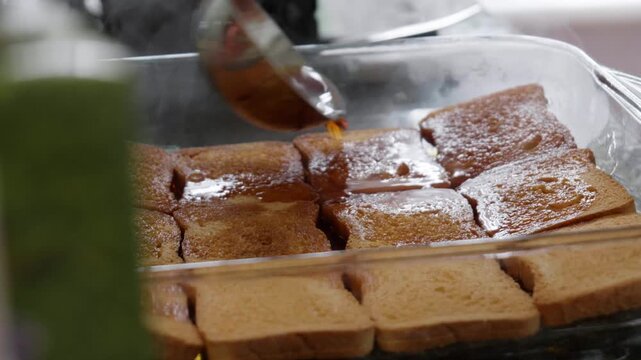 Pouring Hot Sweet Syrup over Toasted Bread Slices in Slow Motion
