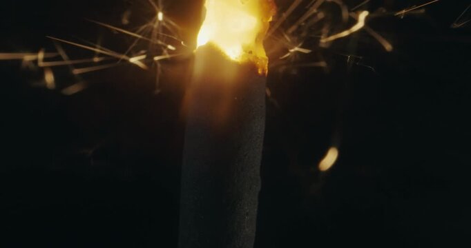 Closeup of bengal lights lightening sparkler burning on the black background, celebration concept, slow motion
