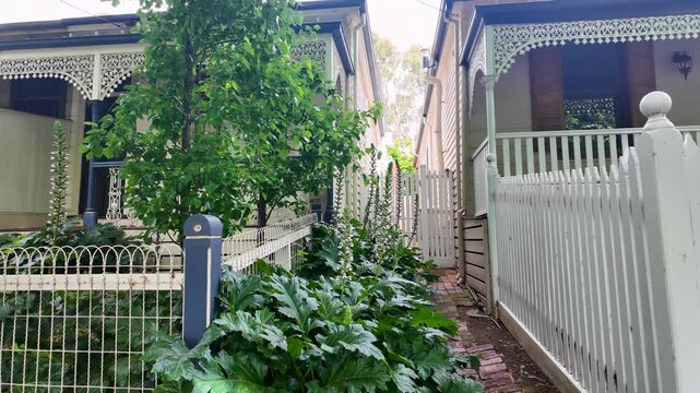Classic historic Victorian terrace houses with decorative veranda lacework, narrow side passage in  Australia. Heritage residential street and preserved inner-city neighbourhood character.