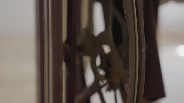 Closeup vintage sewing wheel black cloth, intimate indoor scene showing antique flywheel beside dark fabric, soft warm light on wooden frame, slow rotation suggesting careful mending by tailor, mood
