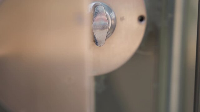 Polished door knob closeup showing repair, metal surface buffed, technician motion implied, screwdriver and cloth context, corrosion removal, stepwise restoration, neutral studio light, focus