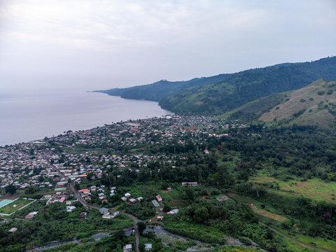An aerial view of a small rural settlement nestled between lush rainforest and the rugged coastline of S&atilde;o Tom&eacute; Island, S&atilde;o Tom&eacute; and Pr&iacute;ncipe.