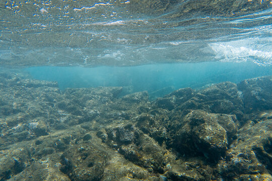 Sunlight refracting through clear turquoise water onto a rocky volcanic reef on Pr&iacute;ncipe Island, S&atilde;o Tom&eacute; and Pr&iacute;ncipe.