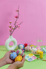 Fototapeta premium Easter egg painting with pastel colors and floral accents