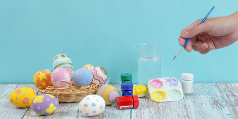 Fototapeta premium Easter egg decorating with vibrant colors and artistic tools