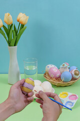 Fototapeta premium Easter egg decorating activity with colorful eggs and flowers