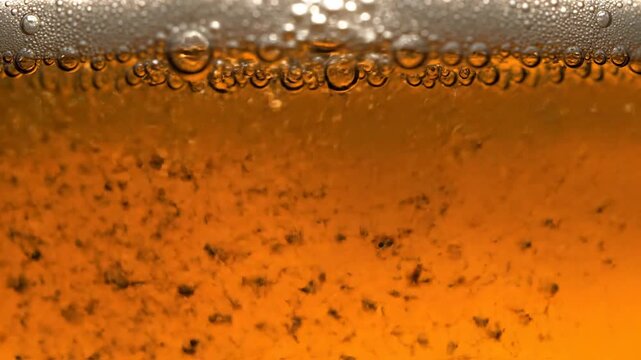 Close-up of Golden Beer with Active Carbonation and Frothy Foam Layer