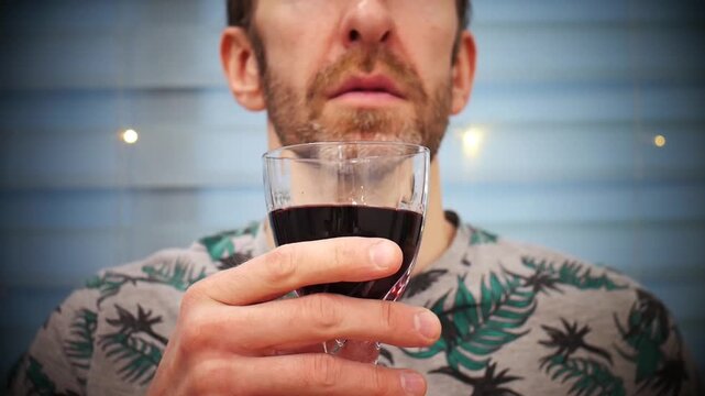 A man takes a small sip of red wine tasting it