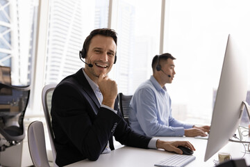 Productive telework. Happy middle aged man in headset fintech customer advisor digital trading...