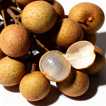 Fresh duku langsat fruit cluster on white background. One fruit peeled open showing translucent flesh. High-quality photorealistic studio shot of tropical Lanzones with natural shadows.