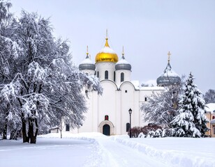 Fototapeta premium Winter Wonderland - A Majestic White Church with Golden Domes Amidst Snow-Covered Trees.