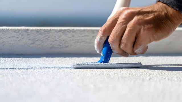 Ultra-realistic close-up of men&rsquo;s hands in gray gloves holding yellow cordless screwdriver with rubberized grip, screw countersinking neatly into roofing sheet