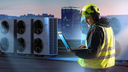 HVAC maintenance. Technician in safety gear checks rooftop air conditioning units with laptop, diagnosing system performance and servicing climate control equipment.