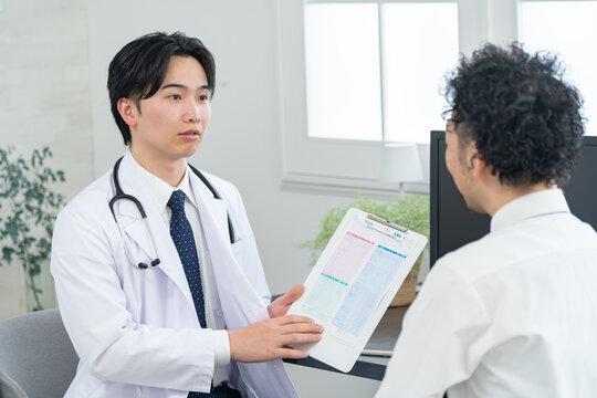 病院で診察する男性