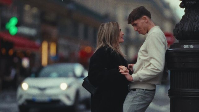 A romantic city trip A couple in love leans against a lamp post on a Paris street shot in a Super 8 film style with a handheld blurry aesthetic commercial or editorial projects