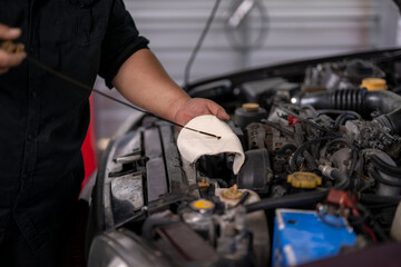 Mechanic checking engine oil level with dipstick