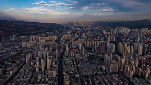 Stunning aerial drone footage of Xining city showcasing modern architecture, illuminated highway bridges, and vibrant night lights against the mountainous Qinghai landscape.