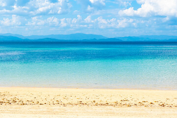 Obraz premium Tropical Nature clear sky and summer sea water under a clear blue sky with beautiful clouds and bright sunlight. Perfect for summer vacation and travel background 