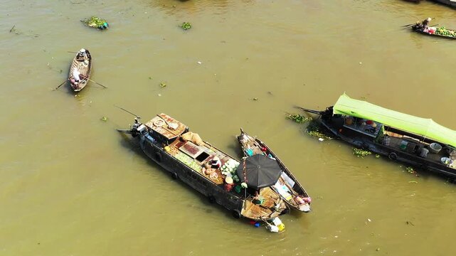 Aerial view of traditional boats at the Cai Rang floating market on a muddy river, showcasing vibrant local commerce and daily life in Vietnam.