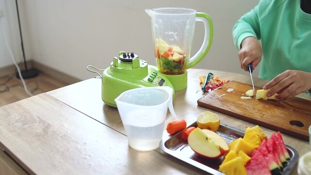 Close-up of hands cutting apple slices for healthy smoothie recipe in kitchen