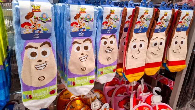 Row of licensed Disney Pixar Toy Story apparel featuring Buzz Lightyear and Woody cowboy character socks on hangers on February 27, 2026 in Bangkok, Thailand