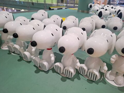 Row of adorable white beagle dog plastic figurines arranged in perspective view for creative retail display or collectible toy exhibition on April 15, 2025 in Bangkok, Thailand