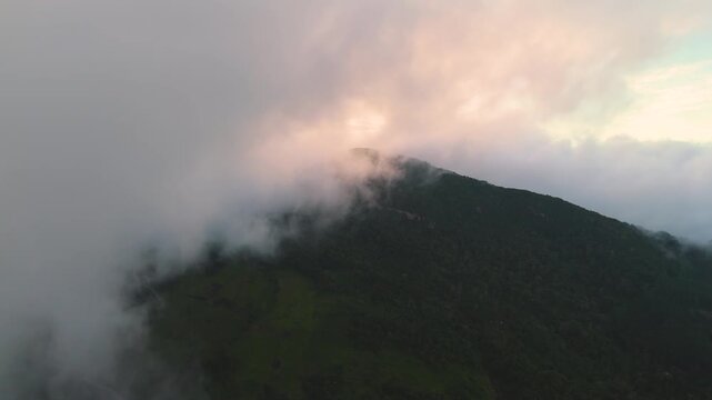 4K dramatic drone flight towards a majestic mountain top hidden in dense ethereal mist