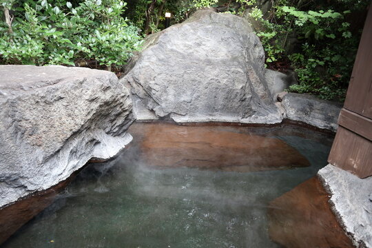 Peaceful outdoor hot spring (Onsen) in Yufuin, Japan, surrounded by nature with no people.