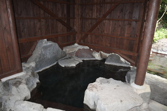 Peaceful outdoor hot spring (Onsen) in Yufuin, Japan, surrounded by nature with no people.