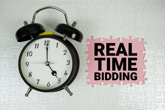 Real Time Bidding (RTB) text with alarm clock on pink background