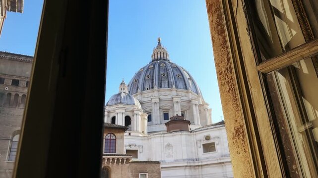 Vatican scene seen through open blinds window with view of Saint Peter basilica church in Vatican City on sunny summer day, Rome, Italy