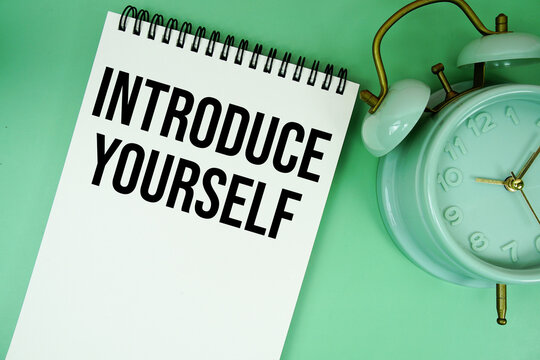 Introduce Yourself text with alarm clock flat lay on green background